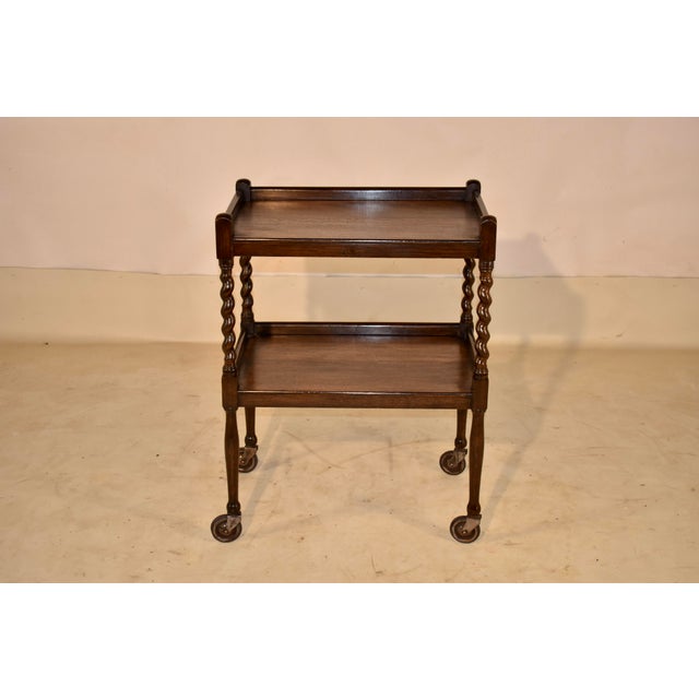 Edwardian oak bar cart from England, circa 1900. This cart has two shelves, both with galleries on three sides. The...