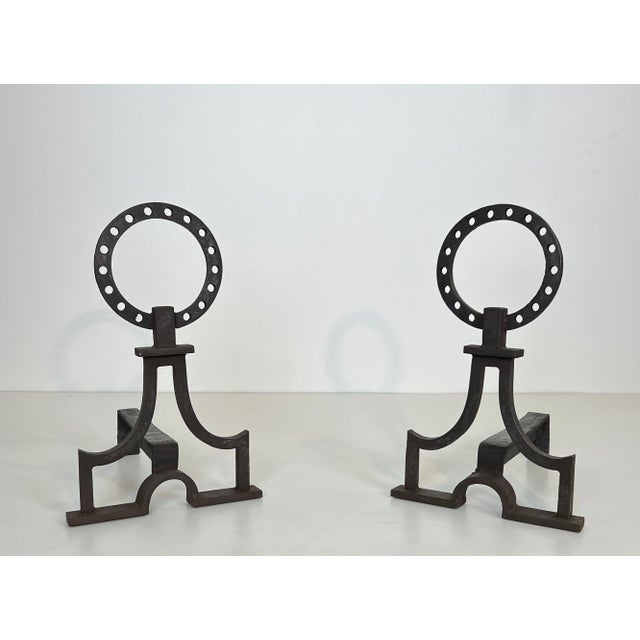 This beautiful pair of modernist andirons is made of wrought iron. It is a French work in the style of Gilbert Poillerat....