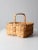 A vintage woven harvest basket featuring traditional splint weaving, a sturdy wooden top frame and handle, and an open-...
