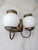 Vintage electric wall sconce featuring an elgeant aged brass scalloped edge backplate and charming milk glass shades.