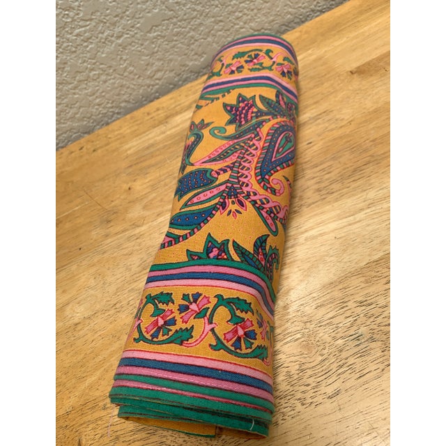 Vintage set of four colorful cotton placemats in orange, blue, pink and green tones.