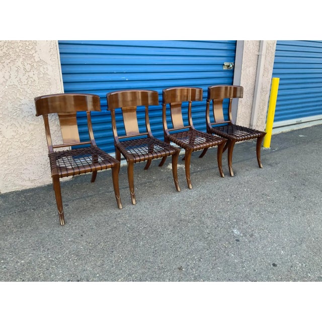 Modern set of Klismos style dining chairs. The chairs are done in a walnut finish. The chairs are quite unique looking and...