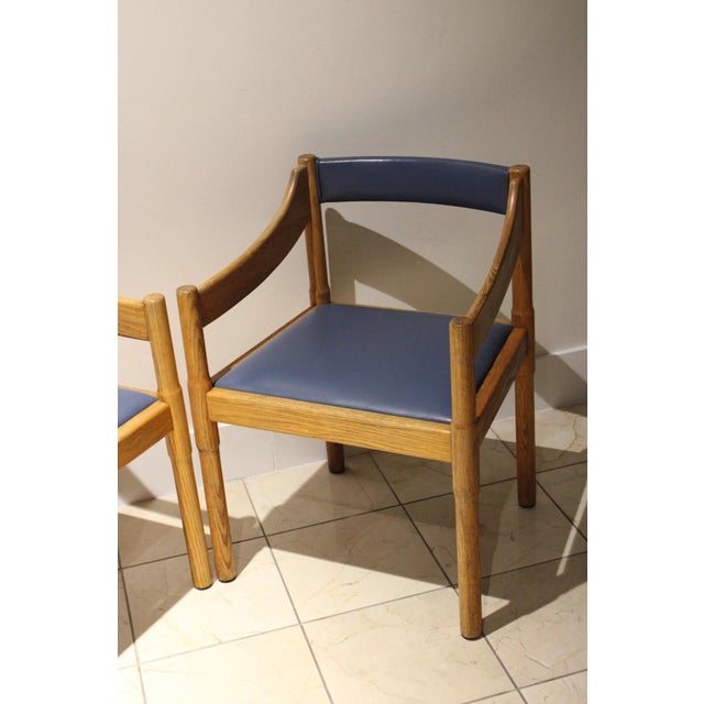 A sophisticated pair of vintage postmodern armchairs crafted from solid oak with beautifully sculpted wraparound arms and...