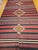 This vintage handwoven kilim rug is a flat-woven with a color palette inspired by the natural beauty of the American...