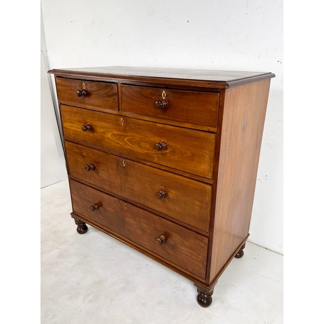 A well proportioned antique mahogany chest of drawers with bone accents, English and dating to about 1860. Doorknob pulls,...