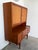 A mid century Danish modern storage hutch. The case is executed in teak and raised on tapered legs. The upper cabinet...