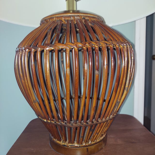 Charming woven rattan table lamp featuring an open basket-style base in a rich warm brown finish. The sculptural woven...