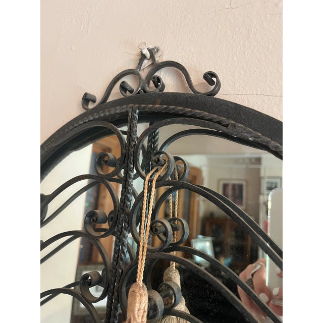 This early 20th-century French antique mirror features a wrought iron frame with intricate scrollwork. A glass shelf...