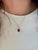 A Madagascar ruby glows with red brilliance at the heart of this oval pendant, framed by a trail of brilliant natural...