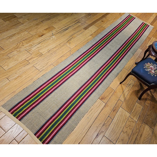 A vibrant and artful vintage American Amish rag runner, handwoven in the early 1900s by Amish and Mennonite communities in...