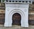 A substantial antique Victorian cast iron fireplace, distinguished by its elegant arched opening, broad architectural...