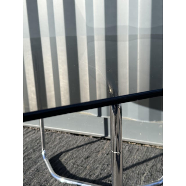 Superb Italian table from the 70s, free-form chrome tubular base on which rests an octagonal smoked glass top one...