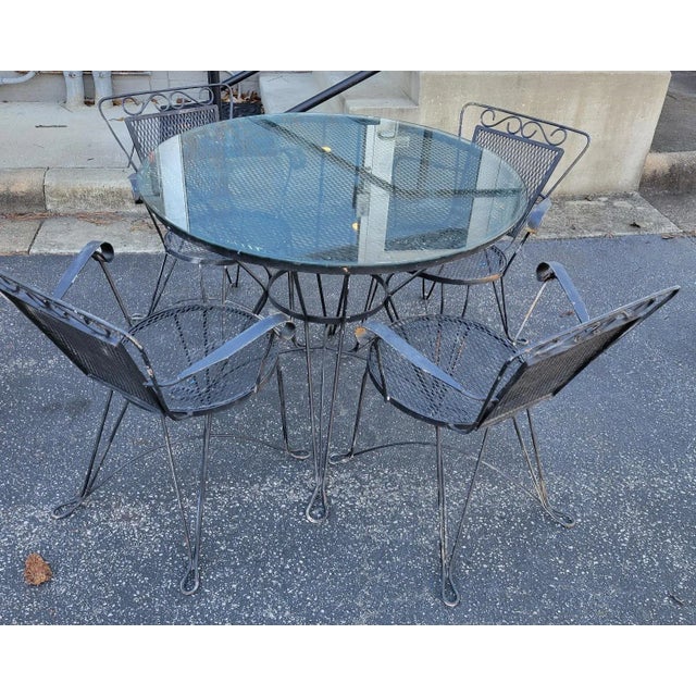Mid 20th C Salterini style 4 black wrought iron chairs with matching wire mesh table having a custom glass top. Can be...