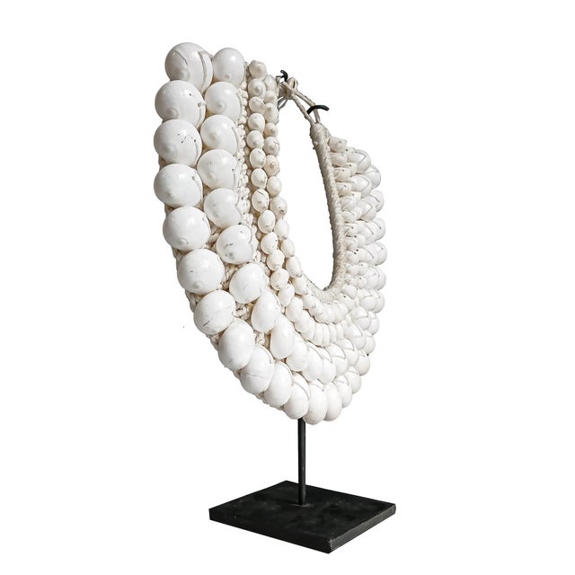 A male necklace from the Asmat Village, Papua New Guinea. Four rows of large polished white cowrie shells in two sizes,...