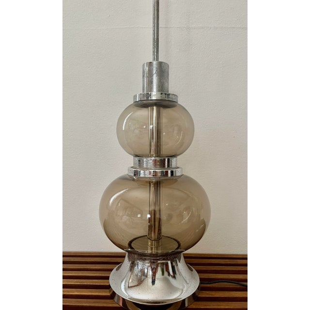 Seductively curvaceous Italian smoked glass table lamp, circa 1970. The soft gray glass with a very subtle amber...
