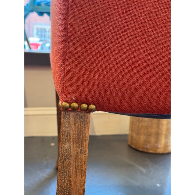 This is an antique wingback chair. It has a fabulous woven wool red shade fabric. There are brass nail head detailing for...
