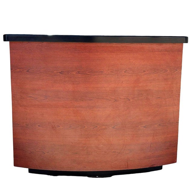 Custom made Modernist curved bar cabinet featuring a walnut exterior paired with a sleek black lacquer top. The gently...