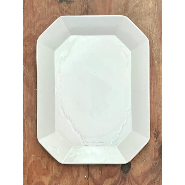This vintage serving platter is a clean, architectural piece of white ceramic, cut in an elongated octagon with softly...