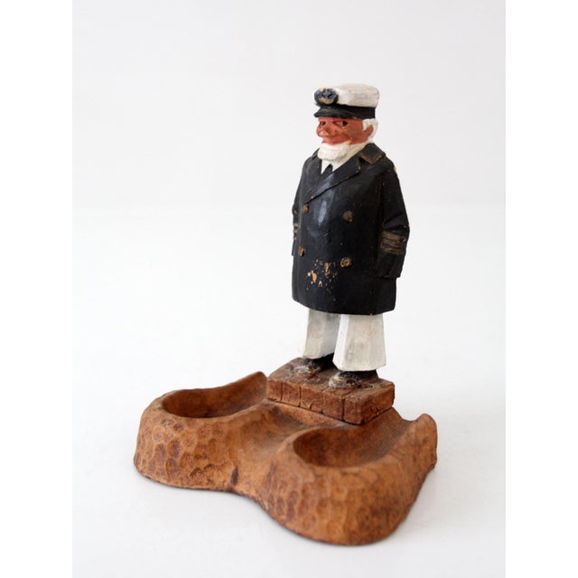 Vintage nautical pipe holder featuring a sculpted sea captain figure and faux burl wood style base. Warm brown tones,...