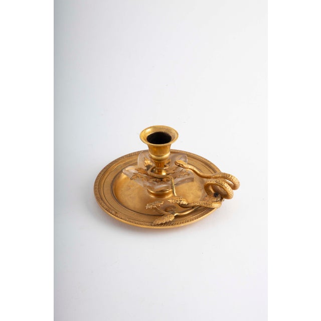 Finely cast gilt-bronze candlestick of circular form, centered by a taper socket mounted upon a faceted rock crystal...