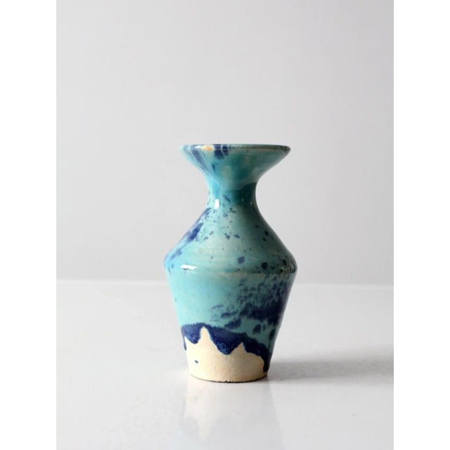 This is a vintage studio pottery vase. The hand-crafted ceramic vessel features a swirling royal blue and turquoise glaze....