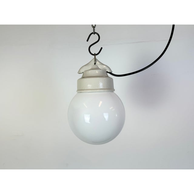 Vintage industrial light made in former Czechoslovakia during the 1970s. It features a white porcelain top and a milk...