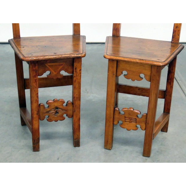 This charming pair of early 20th century Continental side chairs showcases the rustic craftsmanship and decorative...