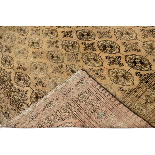 Beautiful antique Turkmen hand-knotted wool rug with a beige field. This piece has brown accents in an all-over geometric...