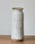 Tall ceramic studio art vase with an earthy, speckled white glaze and an exposed raw clay base. This vintage vase is...