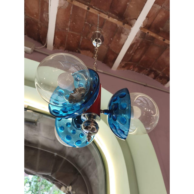 This piece is a Space Age pendant lamp, an iconic design from 1970s Italy. It is characterized by its vibrant combination...