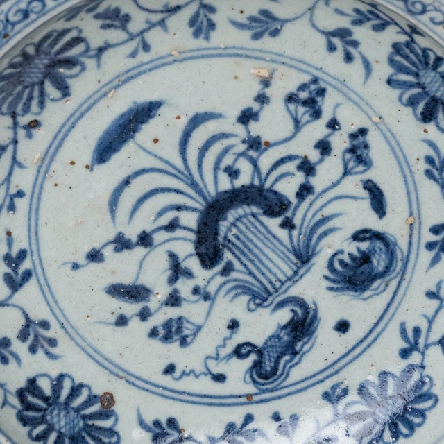 An elevated example of Chinese blue-and-white ceramics, this large, footed dish is brushed with deep cobalt underglaze...