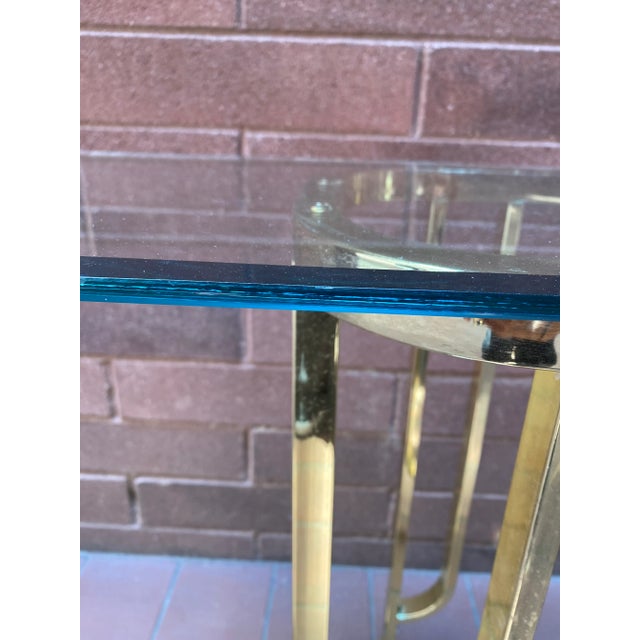 Beautiful and unique Art Deco Console or Sofa Table. Half moon beveled edge glass sits atop a brass base.