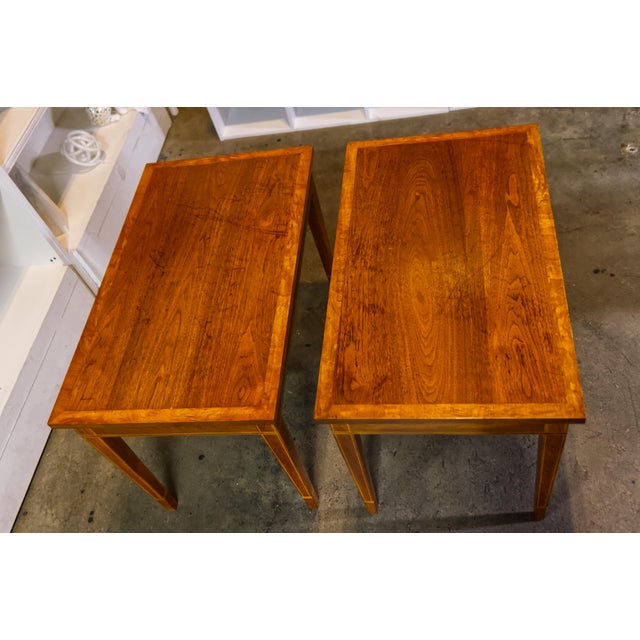 Elegant pair of Edwardian-style walnut side tables featuring intricate marquetry inlay and warm, rich wood tones....