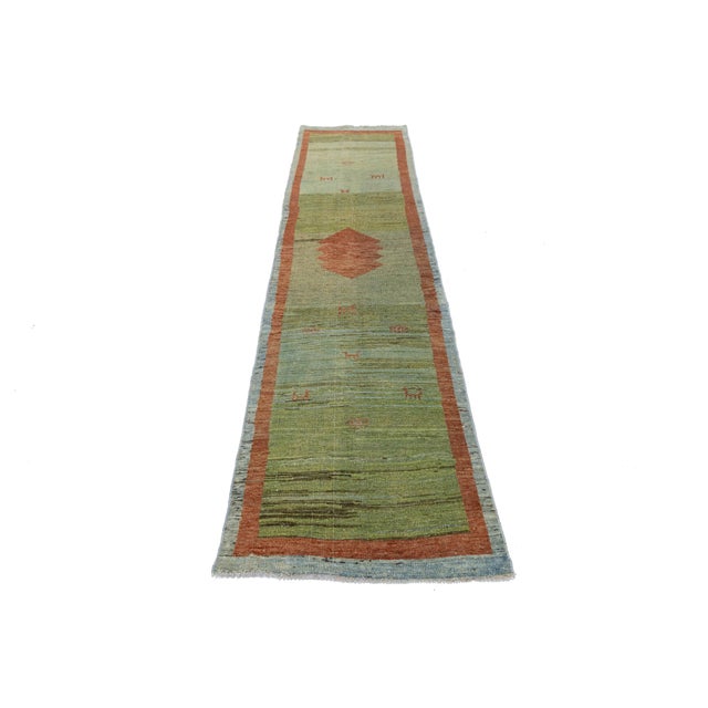 This modern Gabbeh rug combines the raw, soulful heritage of Persian tribal weaving with a sleek, minimalist aesthetic....