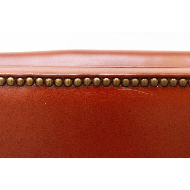 Magnificent leather armchair with footstool Excellent workmanship, simple and elegant lines embellished with metal studs...