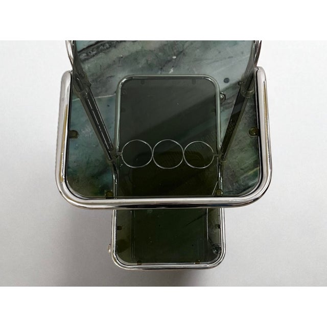 Bauhaus-inspired bar cart with smoked glass shelves and chrome-plated tubular steel frame. elegant vintage serving cart...