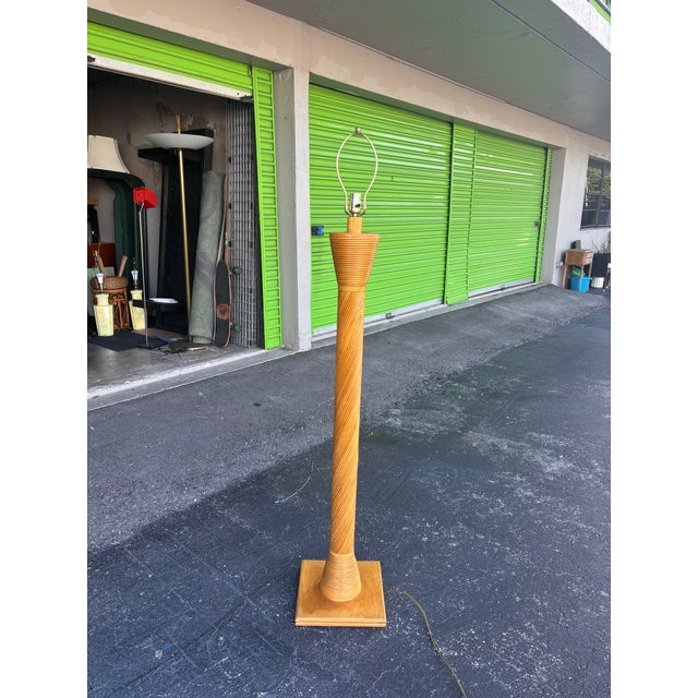 A beautifully sculptural vintage pencil-reed floor lamp, defined by its warm honeyed tone, rhythmic wrapped texture, and...