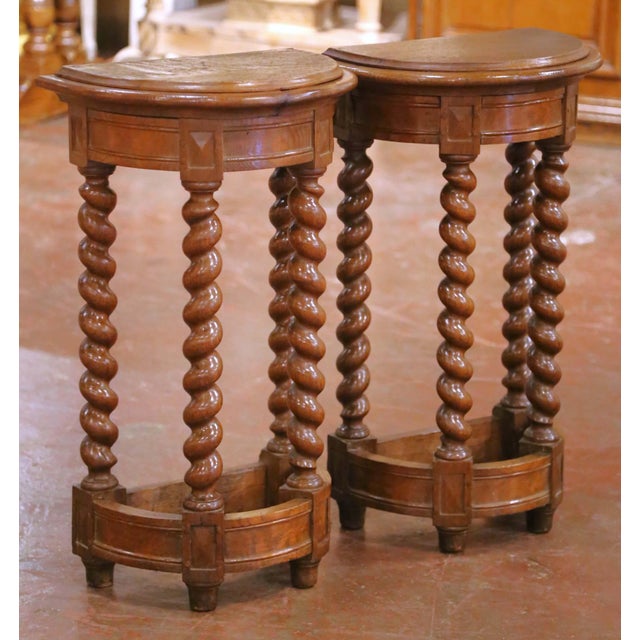 This elegant pair of antique French demi-lune console tables was crafted in oak in the late 19th century, circa 1880, in...
