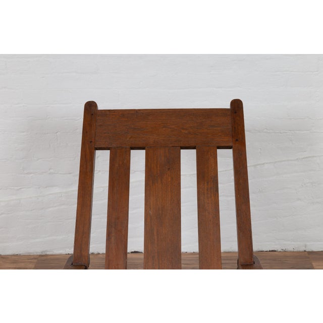 An antique Dutch Colonial early 20th century plantation lounge chair from Madura, Indonesia with slanted back and long...