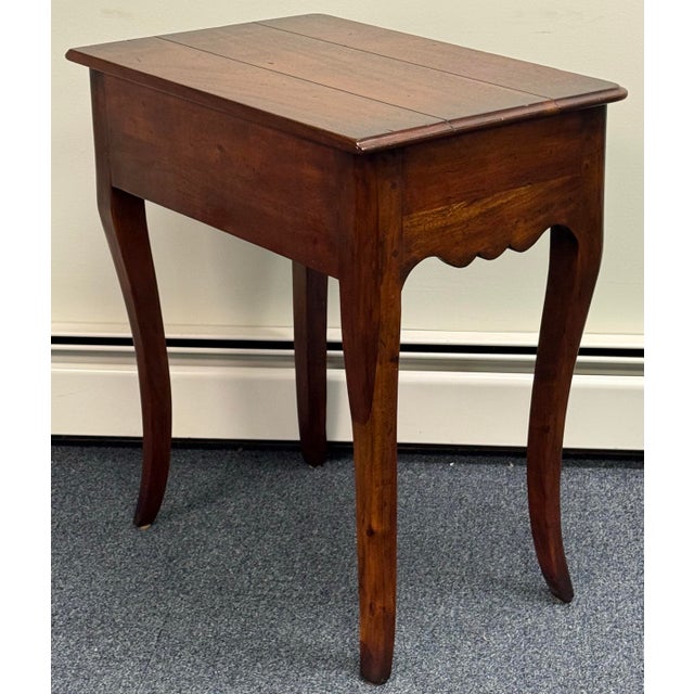 Charming rustic solid mahogany end table features planked top , elegant cabriole legs, one dovetailed drawer and intricate...