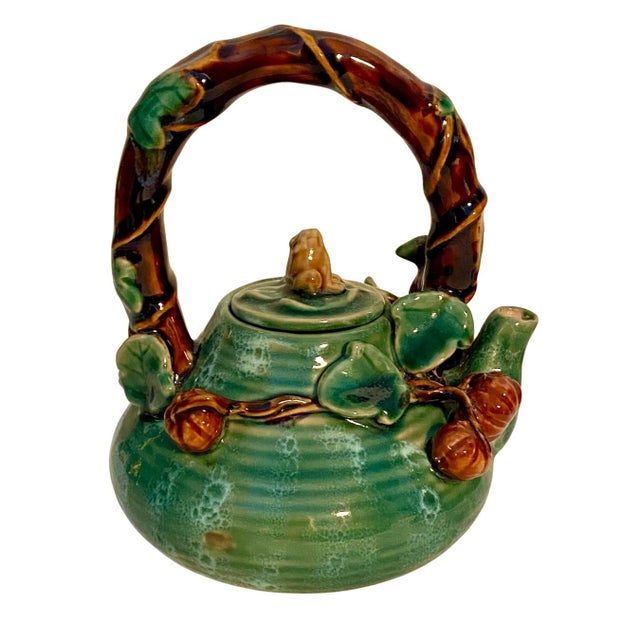 Vintage Majolica ceramic teapot. It features a green glaze and hand decorated with a frog, vines and hazelnuts. Very...