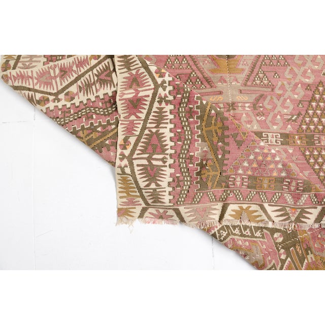 This is a vintage Turkish Oushak rug from the Mid 20th Century. The piece was hand-knotted.