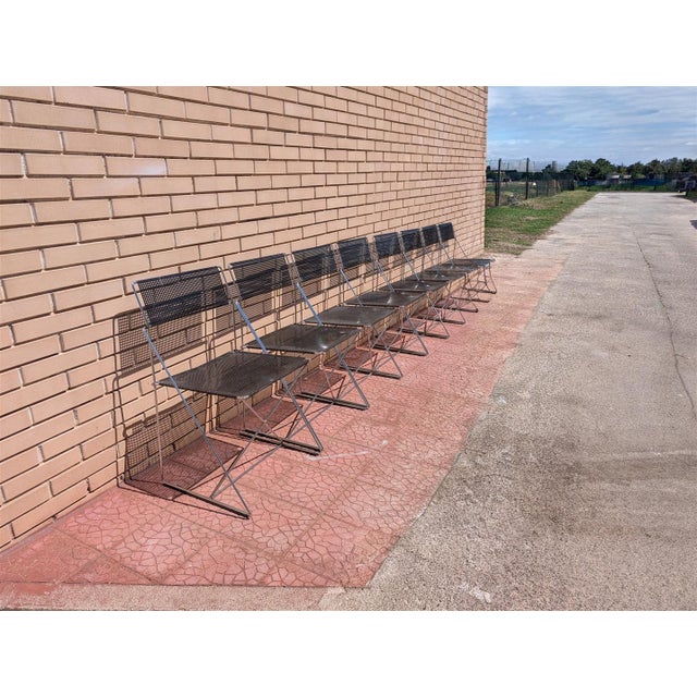 This set of stackable chairs features a minimalist, industrial design, featuring a lightweight chrome-plated metal rod...