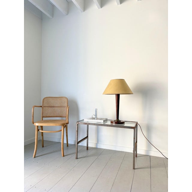 An elegant 20th century French Art Deco wooden table lamp with brass accents. The tapered solid wood stem has a brass...