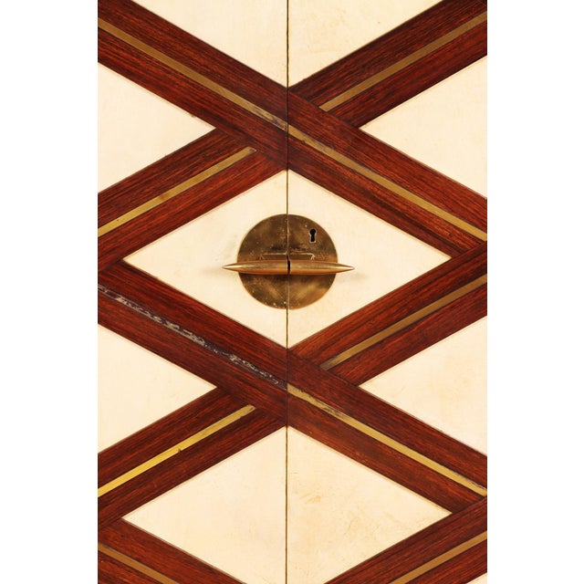 A very good labeled Paolo Buffa for Arrighi Serafino rosewood and parchment front cabinet circa 1940. Having upper open...