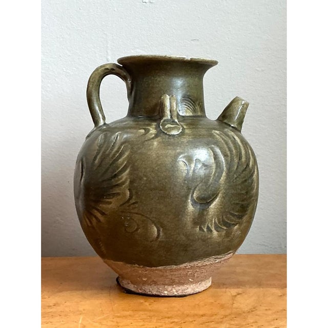 This jug takes a classic amphora-inspired form, its full, rounded body swelling generously outward before narrowing at the...