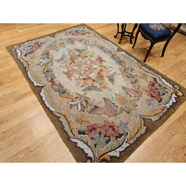 5’ 9” x 8’ 10” (69” x 106”) Vintage American hand hooked room size rug in floral pattern circa the early 20th century. The...