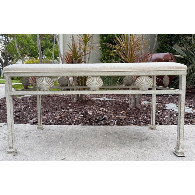 Charming vintage coastal bench featuring a sculptural frame adorned with repeating scallop shell motifs and a richly...