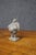 Antique hand-carved stone figure depicting a stout, pot-bellied man standing with his hands behind his back on a...