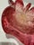 Sculptural hand-blown art glass bowl in rich cranberry pink with a dramatic ruffled freeform rim. The glass is heavily...